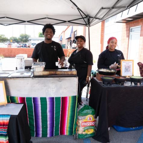 Photo of food stand and employees. 