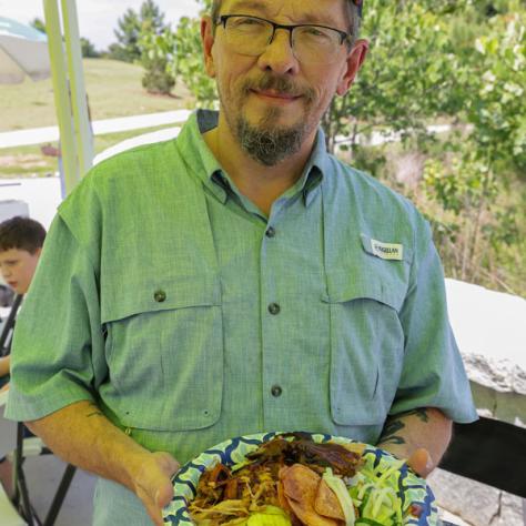 Man posing with plate of food. 