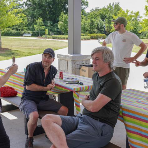 People talking at picnic table. 