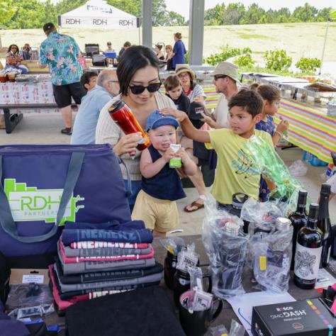 Woman and kids at swag table. 