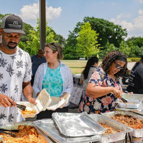 People getting food from buffet. 