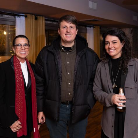 Three people posing for photo. 