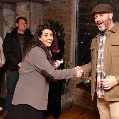 Candid photo of a man and woman shaking hands. 