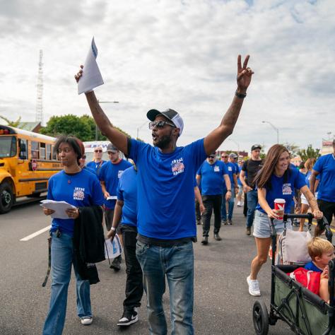 Man marching in parade with hands up. 