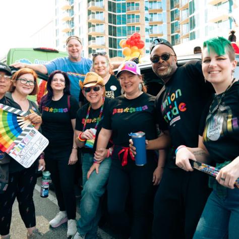 Group of people posing for photo at parade. 