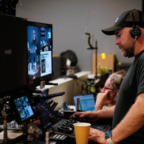 Man with headphones working on screens. 