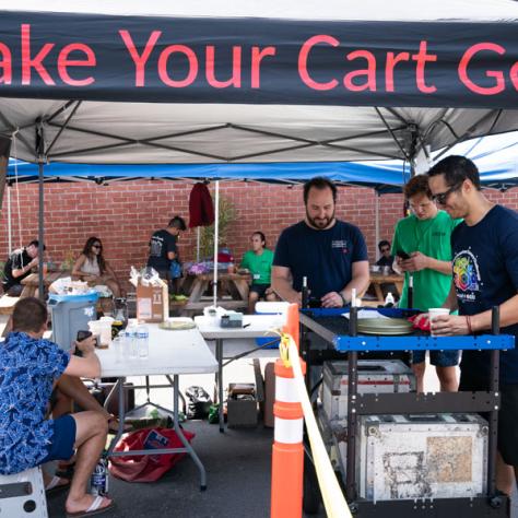 People under 'Make Your Cart Go' tent. 