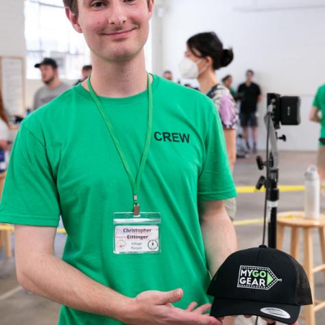 Man holding up hat. 