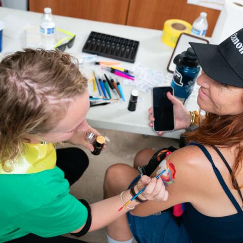 Woman getting her shoulder painted. 