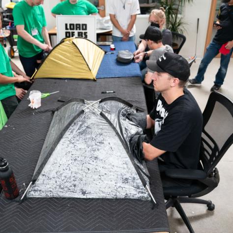 People at tables with mini tents. 