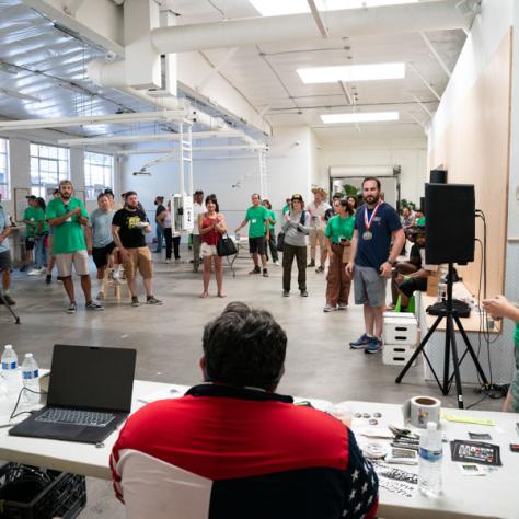 Photo of large room with people standing. 