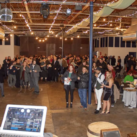 Partygoers watching people talk on stage. 