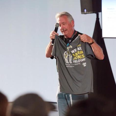 Man holding up shirt to audience. 