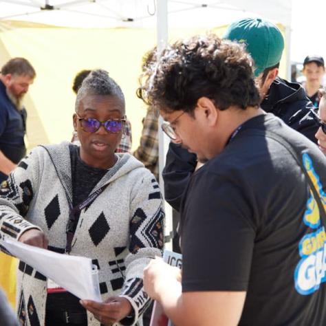 Two people looking at a sheet of paper. 