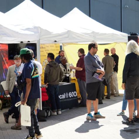 People talking in front of booths. 