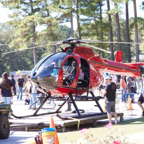 Red helicopter sitting on the ground. 