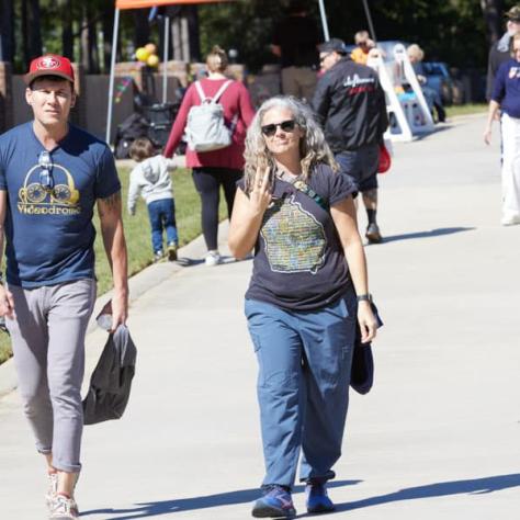 Two people walking on sidewalk.