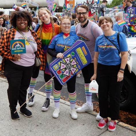 People posing for photo at pride parade.