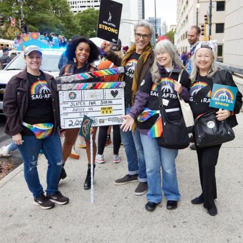 People posing for photo at pride parade.