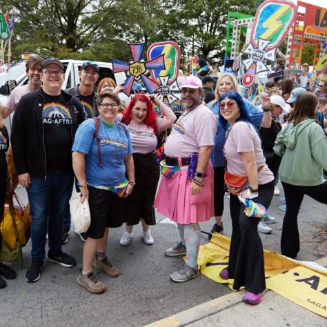 People posing for photo at pride parade.