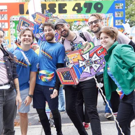 People posing for photo at pride parade.