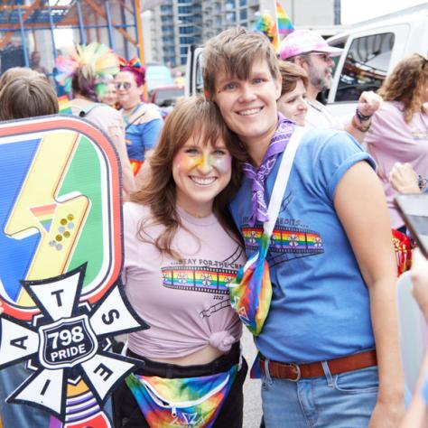 People posing for photo at pride parade.