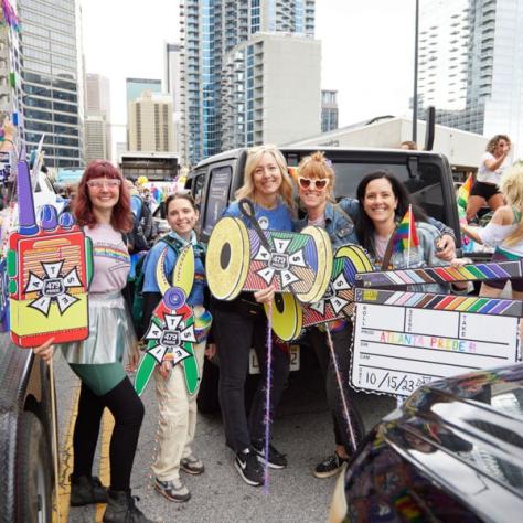 People posing for photo at pride parade.