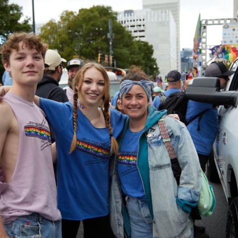 People posing for photo at pride parade.