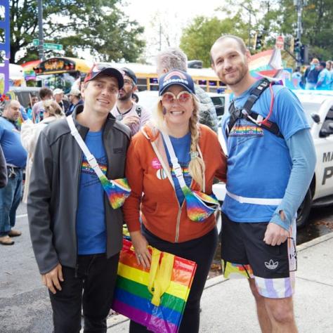 People posing for photo at pride parade.