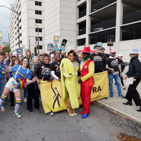 People posing for photo at pride parade.