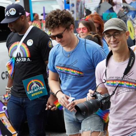 Man with photo at pride parade. 