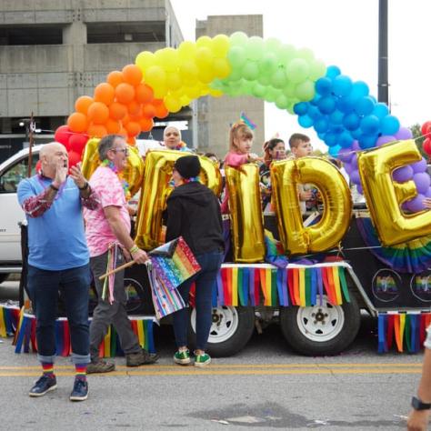 People standing by pride float. 