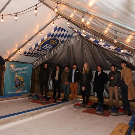 Man speaking to group of people under tent. 