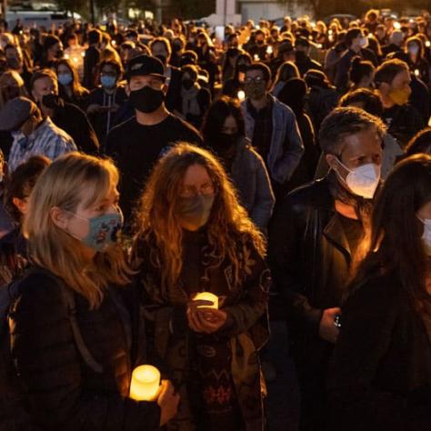 View of people holding candles at vigil. 