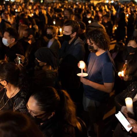 View of people holding candles at vigil. 