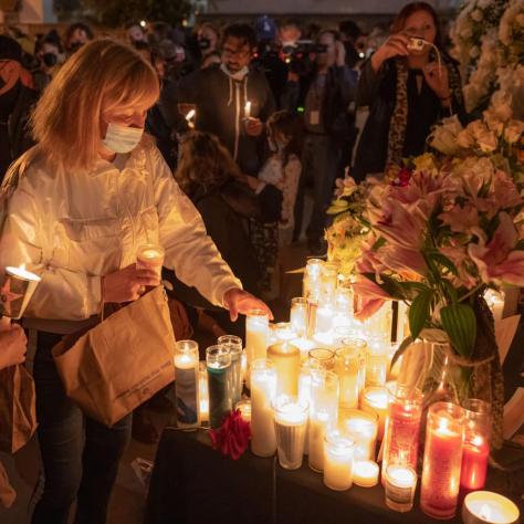 Woman lighting a candle at vigil. 