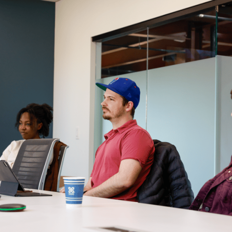 People sitting at a table looking at something. 