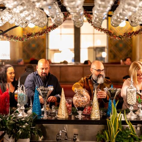 People standing at candy bar at party. 