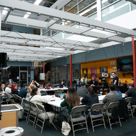 View of room with people sitting at a table. 