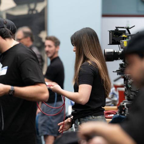 People standing in a room working with camera equipment. 