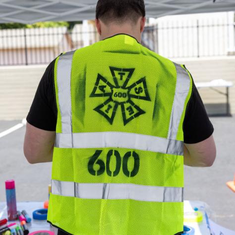 Photo of back of man with reflective vest. 