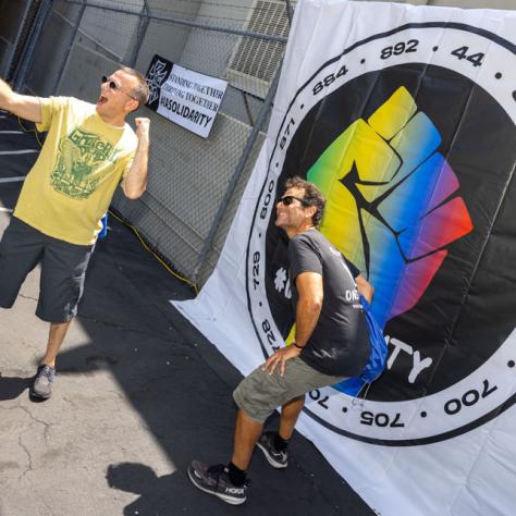 People posing for photo in front of a banner. 