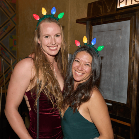 People posing for photo together with Christmas light headbands. 