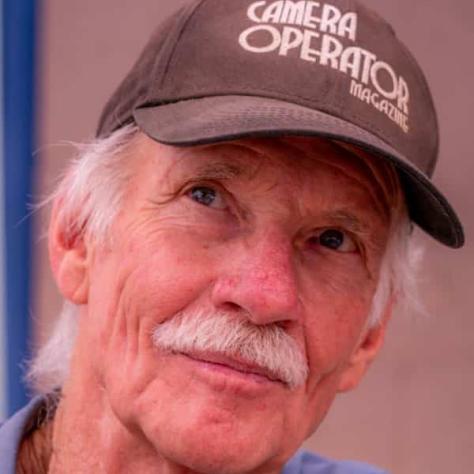 Man posing for photo wearing a hat. 