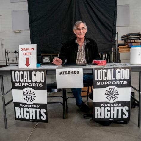 Person sitting at table with signs.