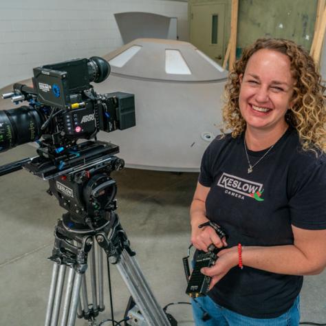 Woman posing for photo with camera. 