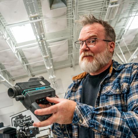 Man posing with a camera. 