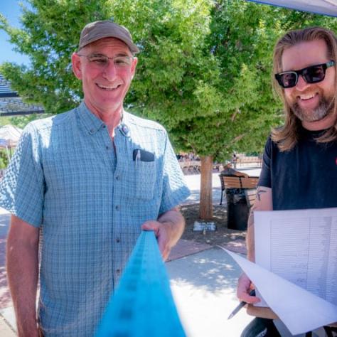 People posing for photo together with papers. 