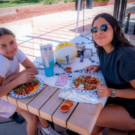 People posing for photo at picnic table. 