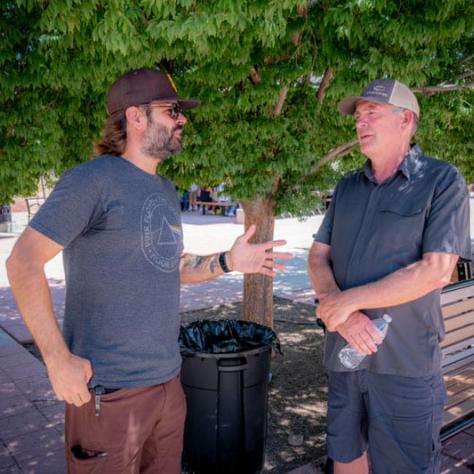 Two men standing and talking. 